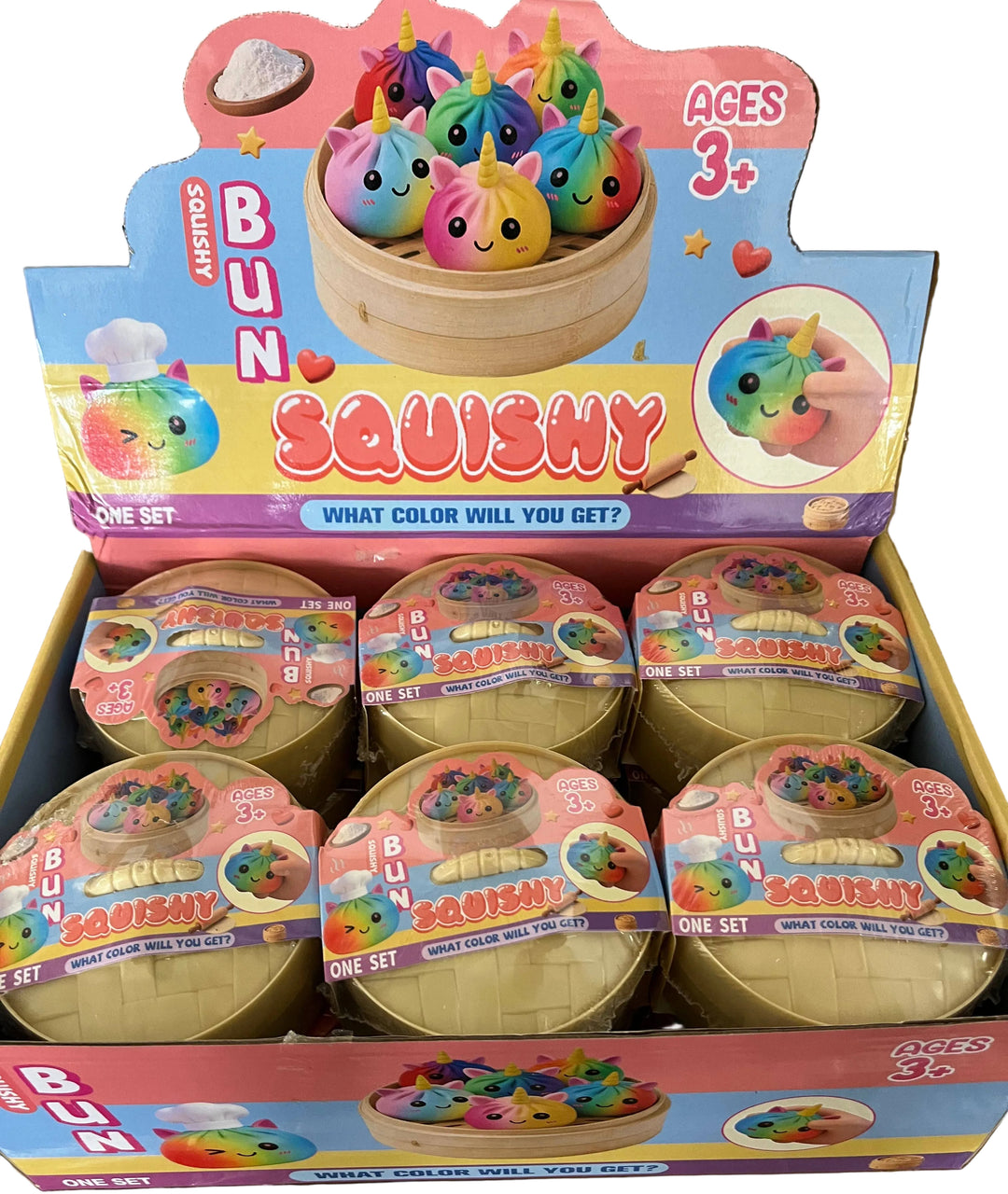 Box of colorful bun squishy toys with packaging indicating 'Ages 3+' on a cardboard surface.
