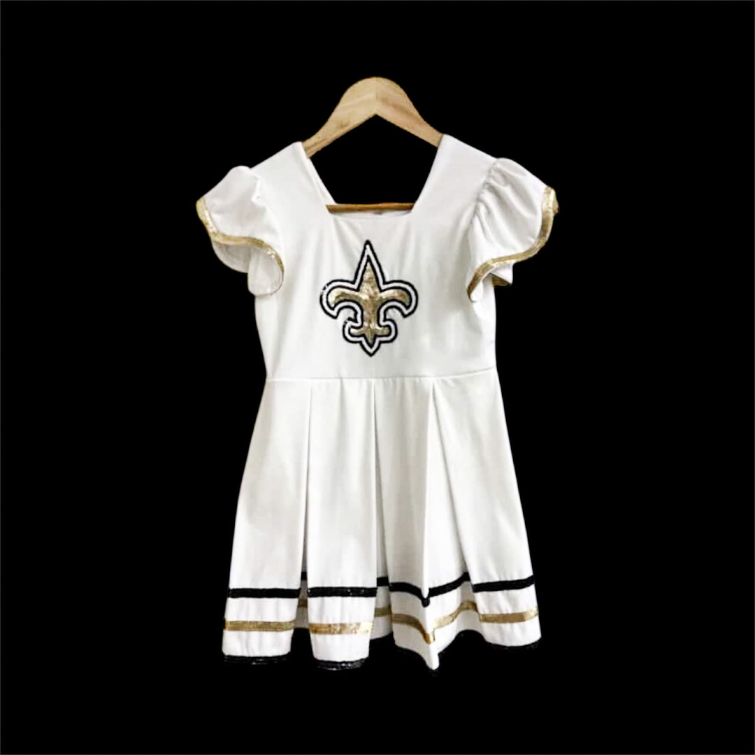 white dress with black and gold sequin fleur de lis in the center of the dress. New Orleans Saints Theme