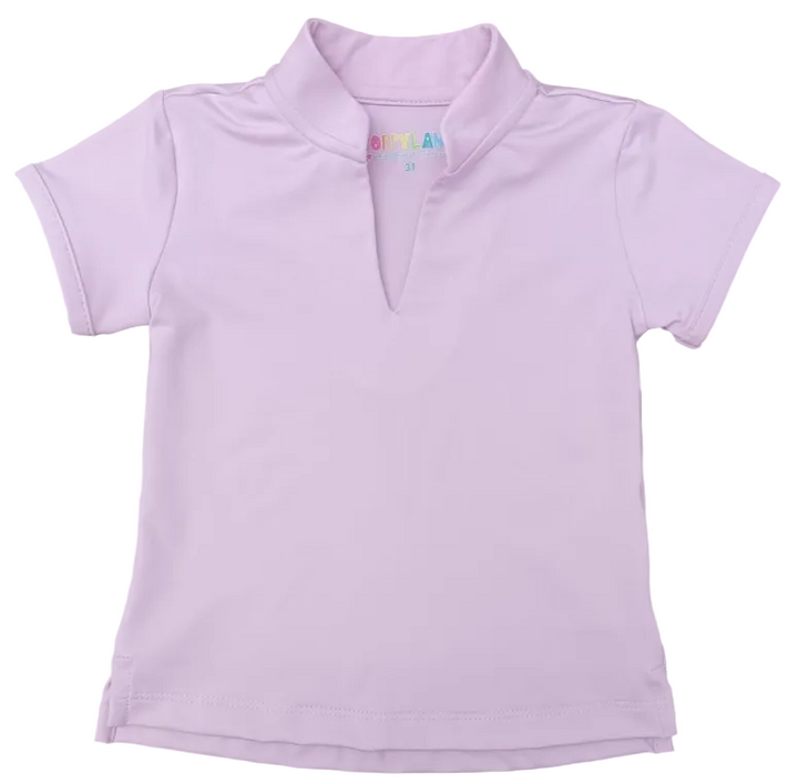 A light pink short-sleeve polo shirt with a split V-neck collar, laid flat on a gray wood-grain surface. The inside collar features a small colorful 'BOMBER' brand label.