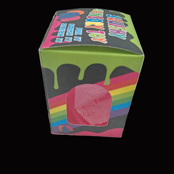 Colorful box with a pink toy inside on a textured surface