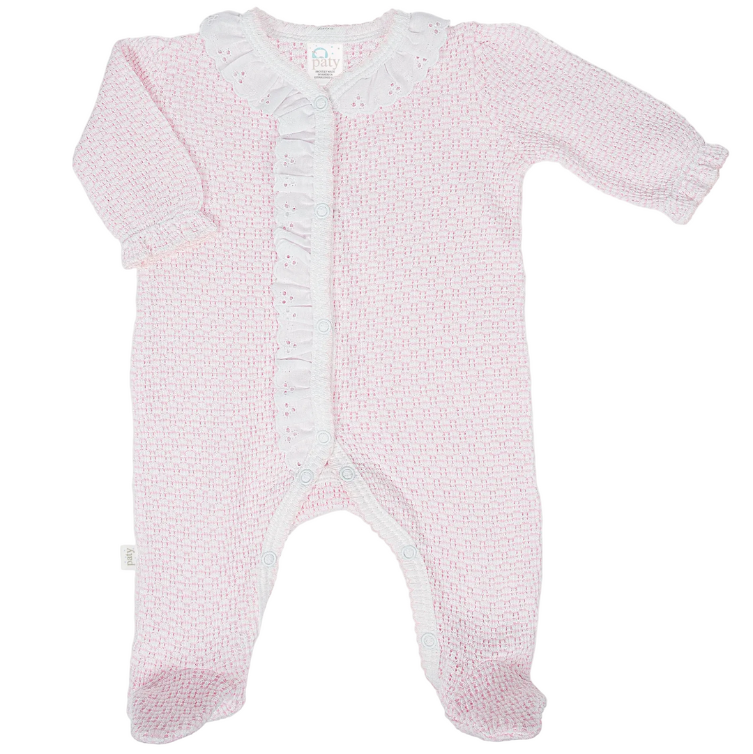 Pink textured baby outfit with a white label on a light gray background