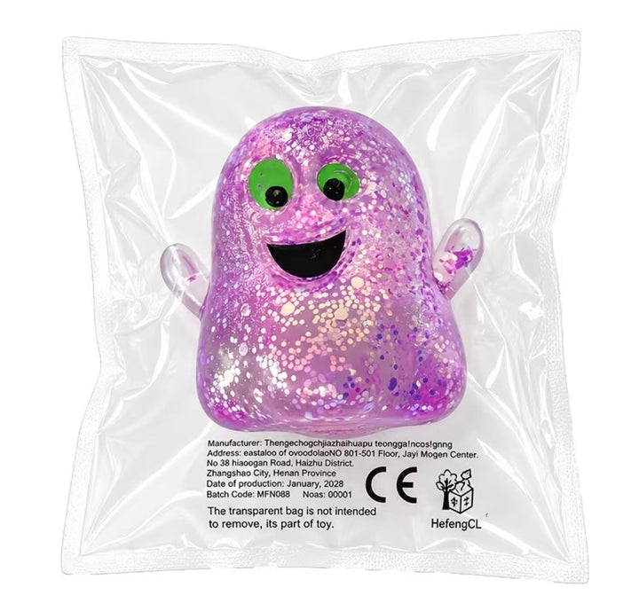 A purple glittery ghost-shaped squishy toy inside a clear plastic bag, featuring green eyes, a black smile, and small clear wings. The bag has printed manufacturer details and a HefengCL logo.