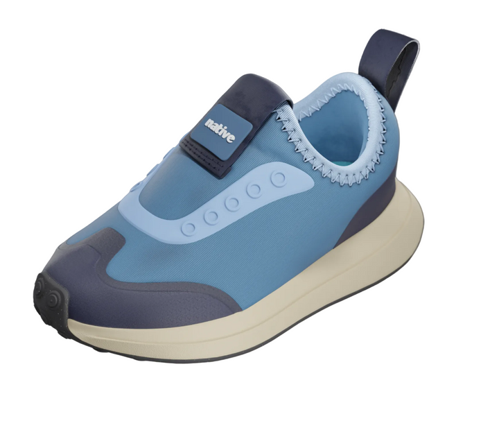 A light blue slip-on sneaker with navy and cream accents, shown on a gray product page background with a 'native' brand tab on the side.