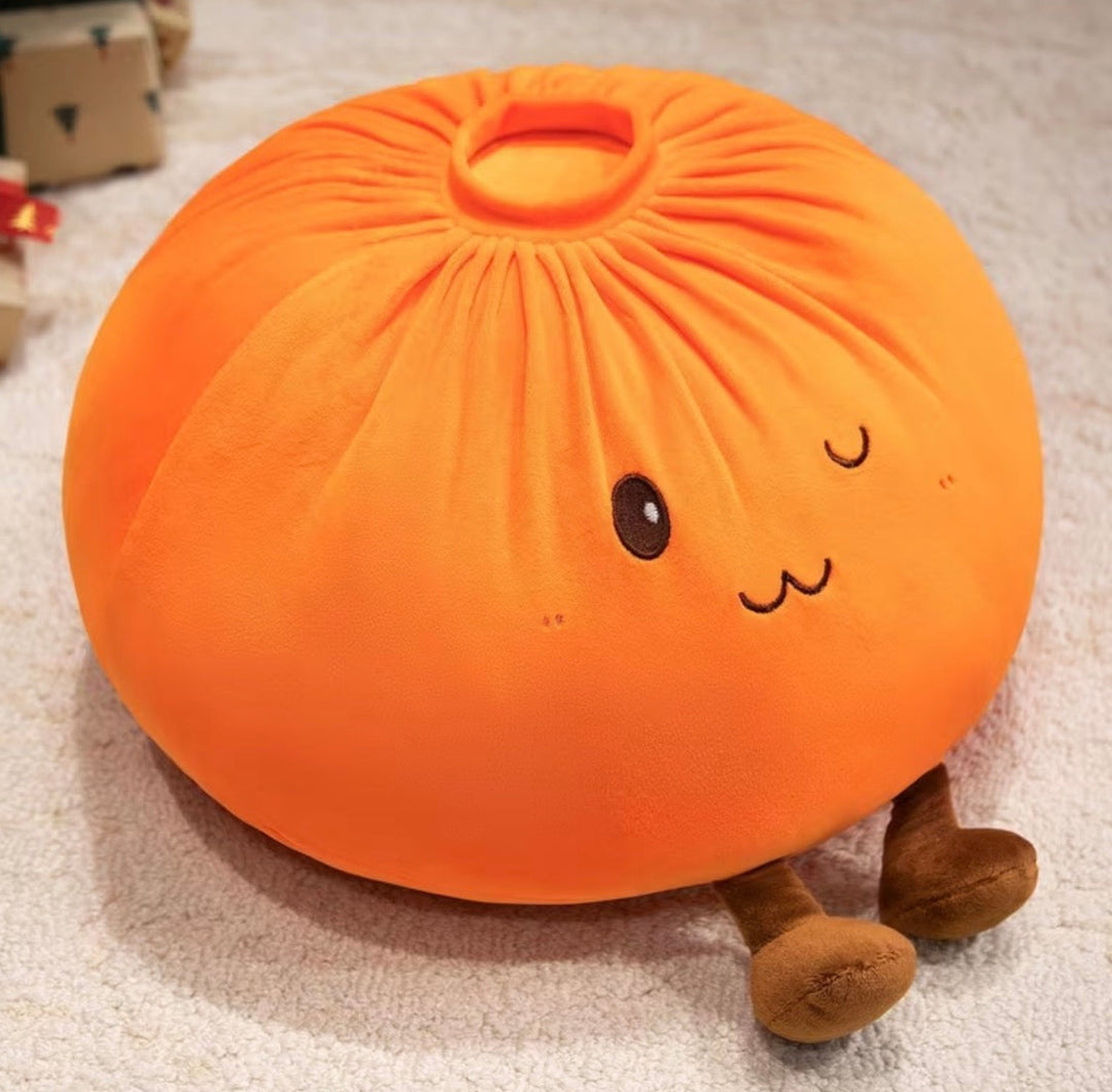 An orange plush pillow shaped like a cute steamed bun (baozi) with embroidered facial features and small brown legs, resting on a light beige carpet.
