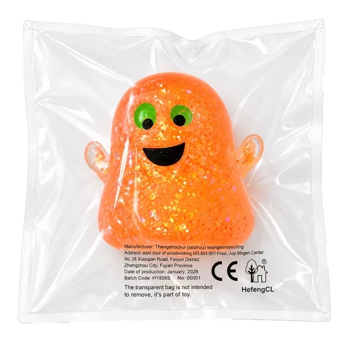 An orange glittery ghost-shaped squishy toy inside a clear plastic bag, featuring green eyes and a black smiley face.