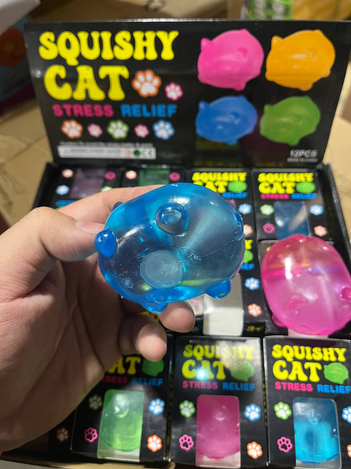 Blue squishy cat toy held in front of a display of similar toys